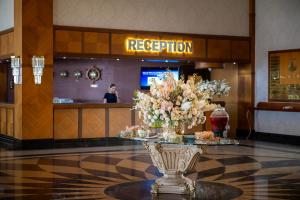 a lobby with a reception counter with a vase of flowers at Porto Bello Hotel Resort & Spa in Antalya