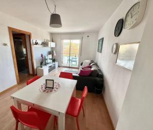 a living room with a white table and red chairs at Acogedor piso en Terrassa in Terrassa