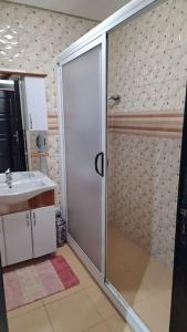 uma casa de banho com um chuveiro e um lavatório. em Spacieux appartement au centre-ville de Tanger em Tânger