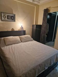 um quarto com uma cama branca e uma janela em Spacieux appartement au centre-ville de Tanger em Tânger