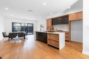 - une cuisine et une salle à manger avec une table et des chaises dans l'établissement O‘Connor 3 bedroom Townhouse in Canberra, à Canberra