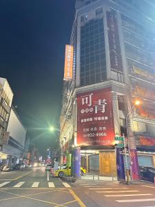 una concurrida calle de la ciudad con un edificio alto con señales en 可青大飯店Grand Ke-Cing Hotel, en Yilan City