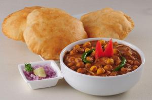 a bowl of food with bread and a bowl of chili at FabHotel Dream Palace in Patna