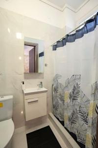 uma casa de banho com um WC, um lavatório e uma cortina de chuveiro em Urban Nest em Tessalônica