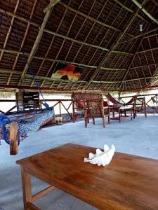 a room with several beds and a wooden table at Karibu Paradaizi in Michamvi
