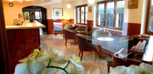 ein Restaurant mit Stühlen, einem Tisch und einer Bar in der Unterkunft Alpenhotel Gastager in Inzell