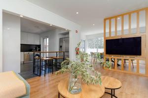 ein Wohnzimmer mit einer Vase auf einem Tisch in der Unterkunft Caparica Dream Vila in Costa da Caparica