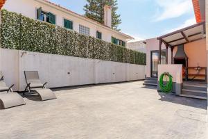 eine Terrasse mit 2 Stühlen und einem Zaun in der Unterkunft Caparica Dream Vila in Costa da Caparica