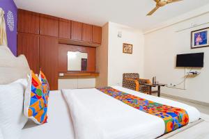 Habitación de hotel con cama y TV en FabExpress Shree Shylee Niwas, en Chennai