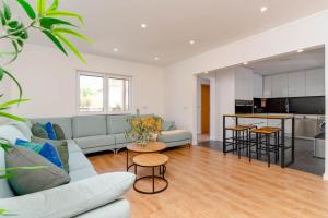 ein Wohnzimmer mit Sofa und eine Küche in der Unterkunft Caparica Dream Vila in Costa da Caparica