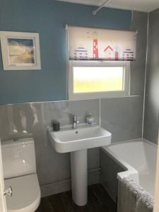 een badkamer met een wastafel, een toilet en een raam bij Margaret Ann Chalet in Seaton