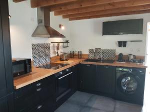 una cocina con fregadero y lavadora en Villa Cocoon, en Saint-Jean-aux-Bois