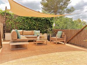 patio z kanapą, 2 krzesłami i stołem w obiekcie MORERABLANCA piscina, barbacoa, chill-out w mieście San Mateo de Bages