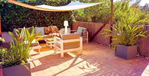 patio z krzesłami, parasolem i roślinami w obiekcie MORERABLANCA piscina, barbacoa, chill-out w mieście San Mateo de Bages