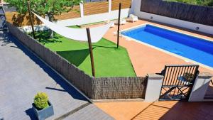 a backyard with a hammock and a swimming pool at MORERABLANCA piscina, barbacoa, chill-out in San Mateo de Bages