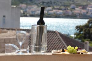 butelkę wina, talerz winogron i szklankę w obiekcie Terrace apartment Beba - Pag w mieście Pag