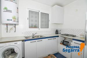 uma cozinha com uma máquina de lavar roupa e um lavatório em Azul Marino em Comarruga
