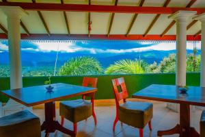 two tables and chairs with a view of the ocean at Siyonra Bungalow in Matale