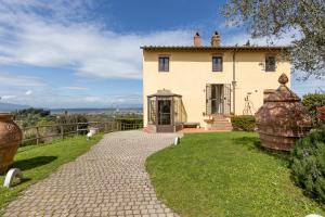 een huis met een stenen loopbrug ervoor bij Residence Montevecchio in Montopoli in Val dʼArno