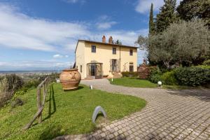 una casa con un jarrón grande delante de ella en Residence Montevecchio en Montopoli in Val dʼArno