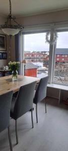 a dining room table with chairs and a large window at Kule gule huset in Svolvær