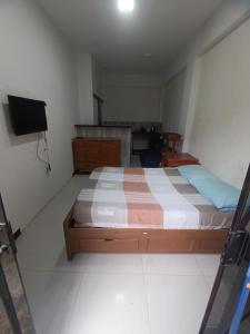 Schlafzimmer mit einem Bett und einem Flachbild-TV in der Unterkunft Monoambiente amoblado céntrico in Trinidad