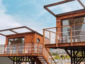 uma casa na árvore com um deque e janelas em El Arrebol Comfort Camp em Jaca