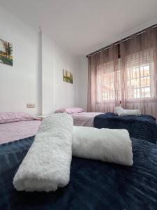 1 dormitorio con 2 camas y toallas blancas. en Piso Azalea Combarro, en Combarro