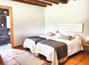 two beds in a room with white walls at La Panera in San Vicente de la Barquera