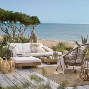 un soggiorno con divano e sedie sulla spiaggia di Villa El Sol At 130 meters from Beach Renewed Nice Area and View a Castelldefels