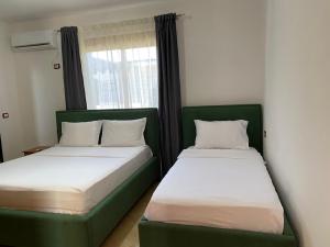 two beds sitting next to each other in a room at Vavla House in Berat