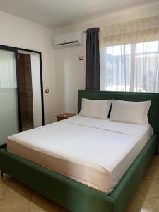 a large bed in a room with a large window at Vavla House in Berat