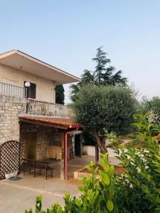 ein Haus mit einem Balkon, einem Tisch und einer Bank in der Unterkunft Villa Lina Monopoli relax in Antonelli