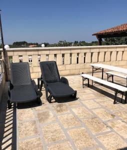 2 Stühle und eine Bank auf einer Terrasse in der Unterkunft Villa Lina Monopoli relax in Antonelli