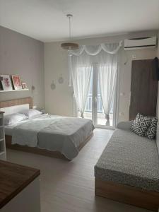 a bedroom with two beds and a window at Our Home-Fully renovated apartments and studios by the sea in Nikiti