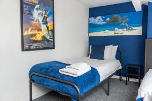 a bedroom with a bed with a movie poster on the wall at 2 Bed House - Sleeps 6 Perfect for Families and Contractors in Leeds