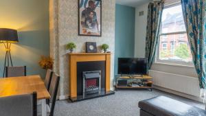 a living room with a fireplace and a television at 2 Bed House - Sleeps 6 Perfect for Families and Contractors in Leeds