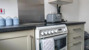 a kitchen with a stove top oven in a kitchen at 2 Bed House for Contractors in Leeds