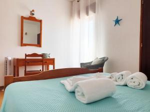 una camera da letto con un letto e asciugamani di Albufeira Apart AE - Sea & Old Town View ad Albufeira