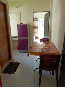 a kitchen with a table and a purple refrigerator at Star Night stay family Studio AC Apartment in Dhaka