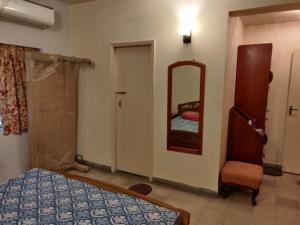 a bedroom with a bed and a mirror and a chair at Lovely couple friendly guest house in Kolkata