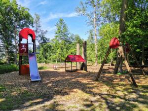 a playground with a swing set and a slide at Hotel Schlösschen Sundische Wiese Zingst in Zingst