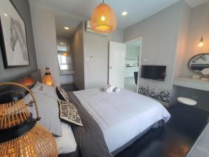 a bedroom with a white bed and a television at Prio 机场 in Chiang Mai