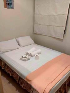 Una cama con una manta rosa y blanca. en #35 Grass residences tower2, en Manila