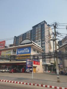 a city street with a large building in the background at Prio 机场 in Chiang Mai
