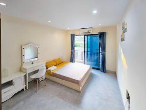 a bedroom with a bed and a desk and a mirror at Hanoi Delight House in Hanoi