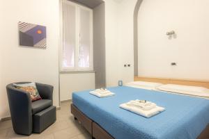 a bedroom with a blue bed and a chair at Affittacamere del Golfo e delle 5 Terre in La Spezia