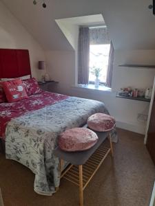 a bedroom with a bed with two ottomans and a window at No 27 in Inverness