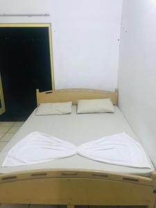 een bed met twee kussens in een kamer bij WHITE ROSE VILLA in Kandy