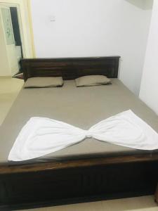 een bed met witte lakens en kussens erop bij WHITE ROSE VILLA in Kandy